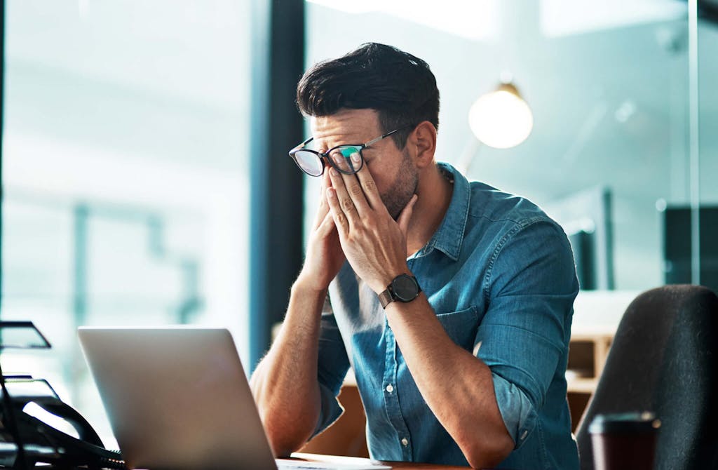 a man stressed out working at his laptop